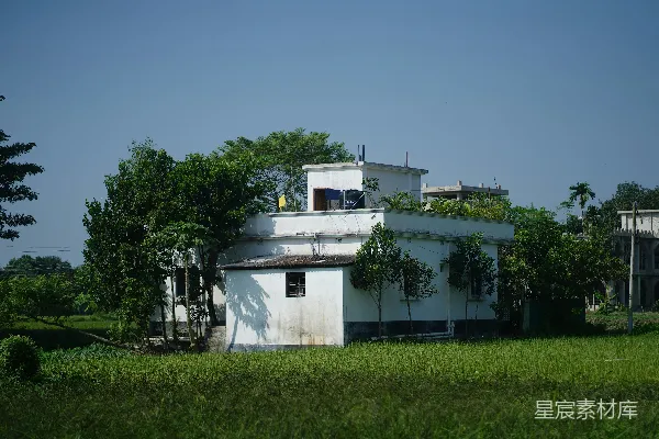 高清摄影 白色建筑被茂盛的绿树和草地环绕。