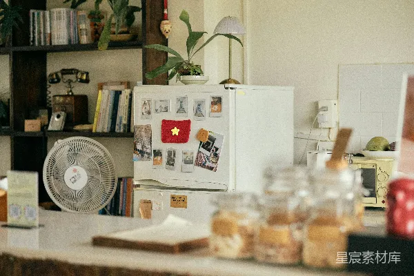 高清摄影 冰箱上有一个国旗磁铁、风扇和几个罐子放在柜台上。