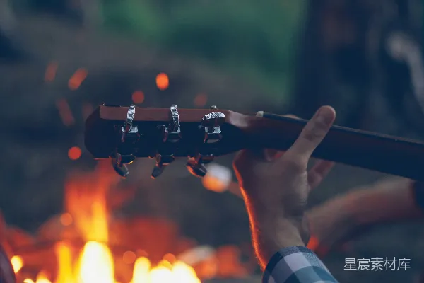 高清摄影 晚上在篝火旁弹吉他。
