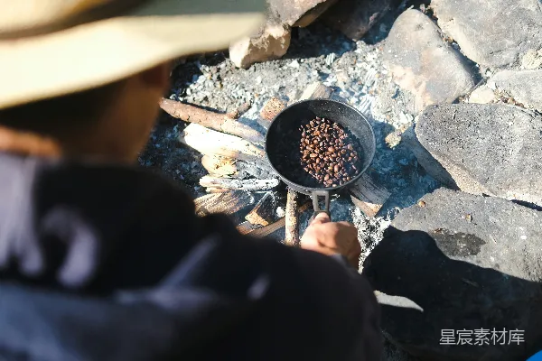 高清摄影 一个男人正在篝火上做饭。