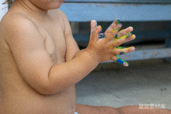 裸露上半身的孩子，绿色、蓝色和紫色的指甲彩绘