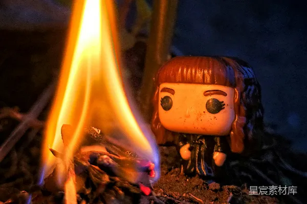 高清摄影 一个可爱的Funko Pop玩偶坐在篝火旁边。