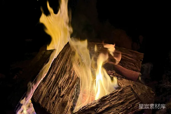 高清摄影 篝火在夜晚燃烧得明亮，周围有木头。