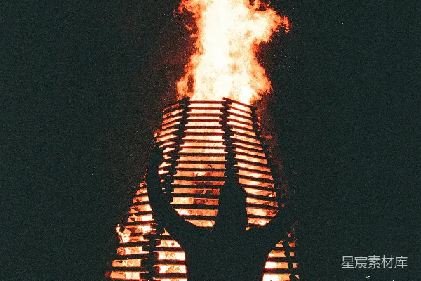 高清摄影 一个人在夜晚巨大的篝火前剪影。