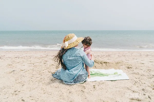 高清摄影 抱着幼儿的女性在海边前