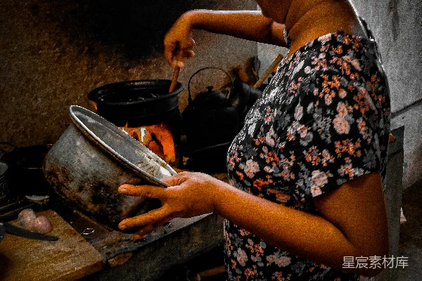 高清摄影 一个女人在炉子上的锅里做饭。