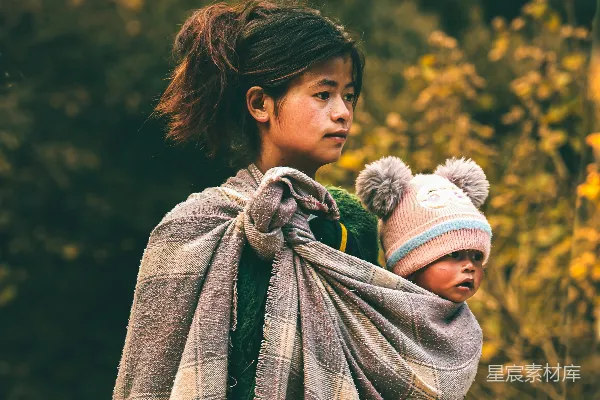 高清摄影 一个年轻女孩抱着用毯子包裹着的婴儿。
