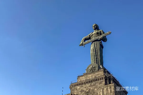 高清摄影 一座男人手持剑的雕像矗立在建筑物的顶端。