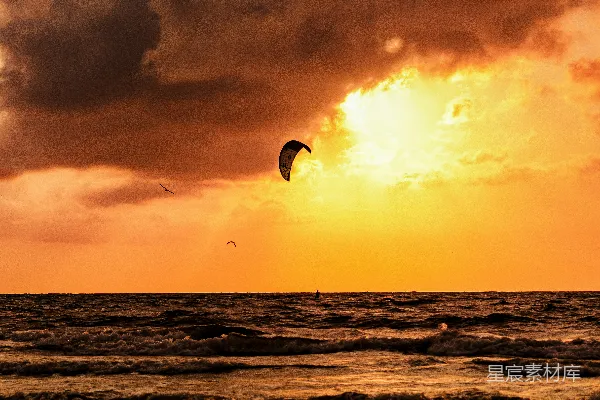 一个人在夕阳西下时驾帆航行于海洋中