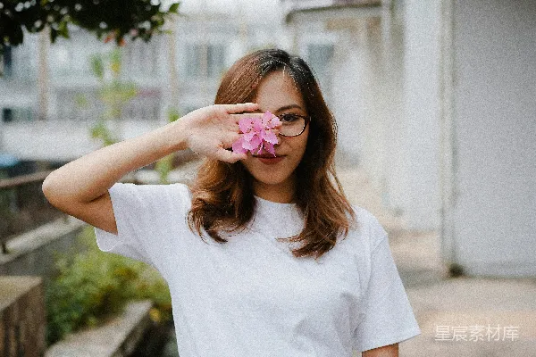 高清摄影 穿着白色圆领T恤，耳朵上戴着粉色花朵耳环的女人