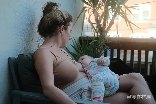 高清摄影 一位坐在长椅上的妇女抱着一个婴儿。