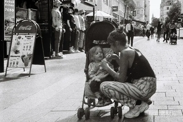 高清摄影 一个女人跪在婴儿车旁边。