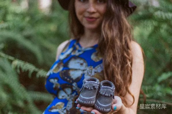 高清摄影 抱着婴儿的鞋子的女人