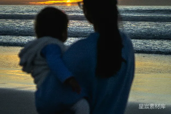 高清摄影 穿白色长袖衬衫的女人站在海滩上，夕阳西下。
