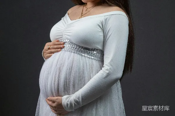 高清摄影 穿着白色连衣裙的孕妇温柔地微笑着。