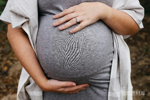 高清摄影 一位孕妇用手托着她的肚子。