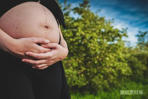 高清摄影 一名孕妇用手托着自己的腹部。
