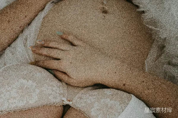 高清摄影 一个穿着白色内衣的孕妇躺在床上。
