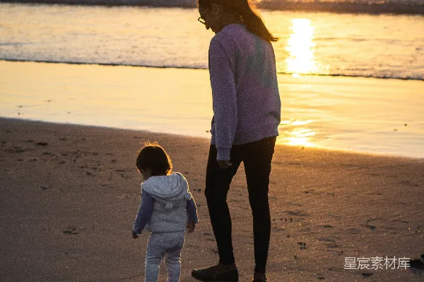 高清摄影 穿着白色长袖衬衫和黑色裤子的女性在白天的海滩上行走。