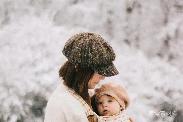 高清摄影 一个抱着用毯子包裹着的婴儿的女人