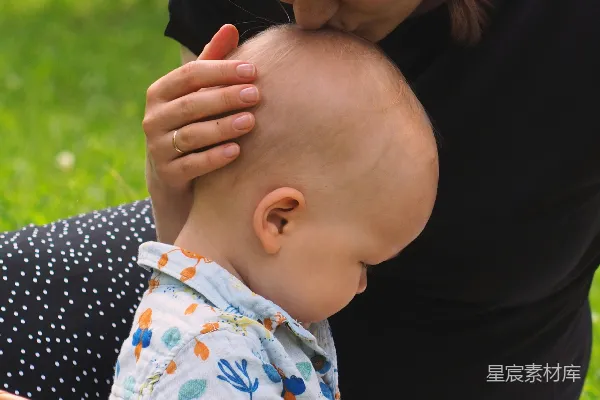 高清摄影 一位女士坐在毯子上抱着一个婴儿。