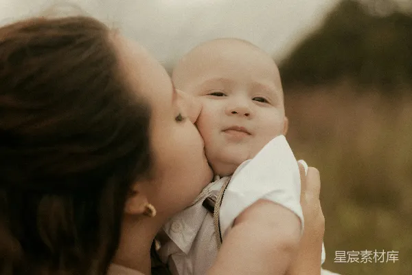 高清摄影 母亲在户外亲吻她的婴儿。