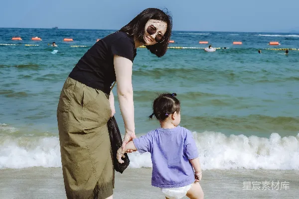 高清摄影 在沙滩上，女人和婴儿手拉手。