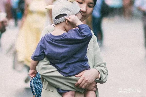 高清摄影 一个女人在繁忙的街道上抱着一个孩子。