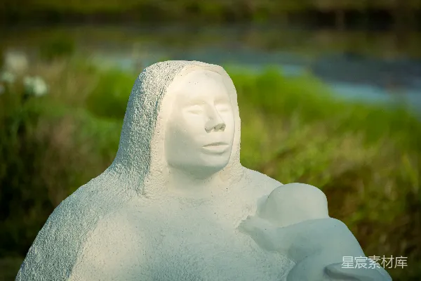 高清摄影 白天的绿色草地上，白色陶瓷天使雕像