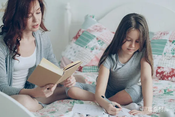 高清摄影 妈妈在读书，女儿在床上画画。