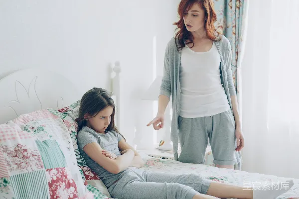 高清摄影 母亲在责骂坐在床上的女儿。