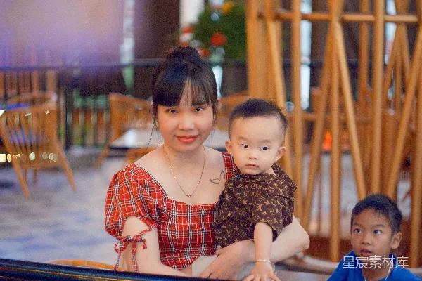高清摄影 母亲抱着她的孩子，旁边还有另一个孩子。