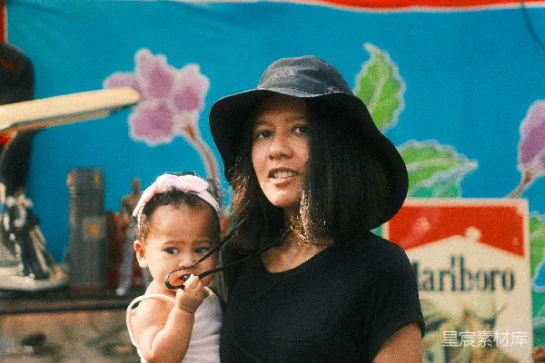 高清摄影 一个女人在市场摊位抱着一个婴儿。