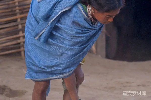 高清摄影 背着婴儿的女人用扫帚扫地上的灰尘