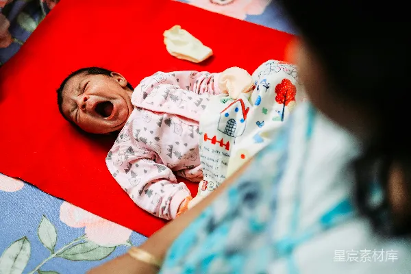 高清摄影 一个婴儿躺在红色地毯上打哈欠。