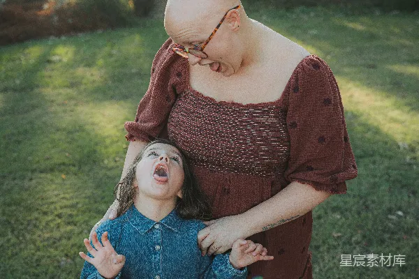 高清摄影 光头的妇女和孩子在户外抬头看。