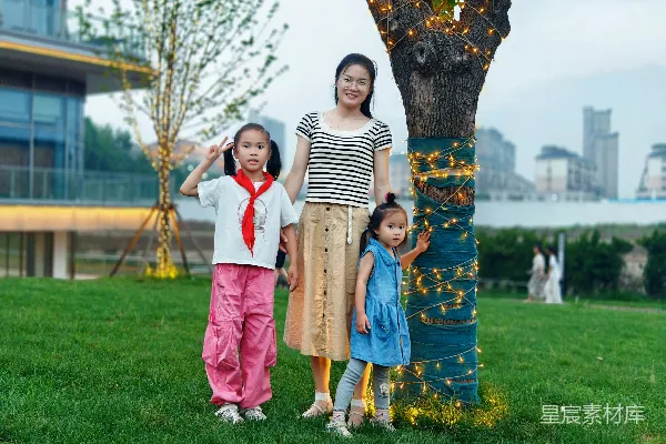 高清摄影 母亲和两个女儿站在一棵装饰好的树旁