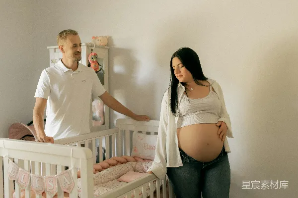 高清摄影 一对夫妇站在幼儿园的婴儿床旁边。