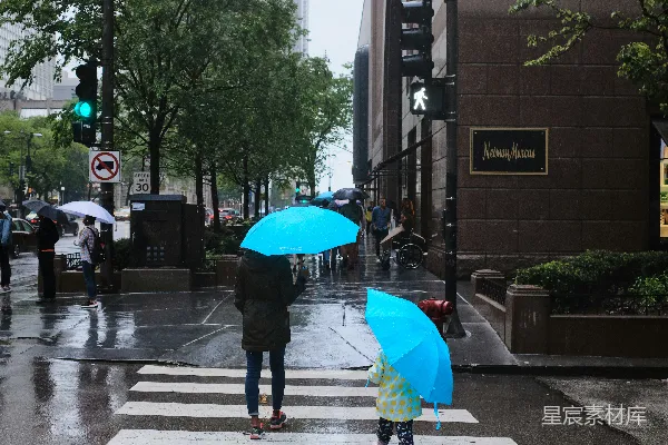 高清摄影 一位女士和一位女孩在人行道上边走边打着雨伞。