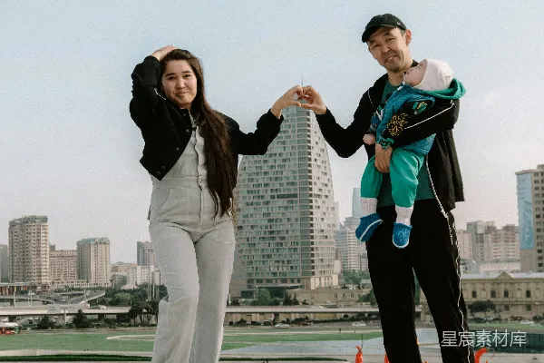 高清摄影 一对带着婴儿的夫妇站在屋顶上，俯瞰着城市建筑。