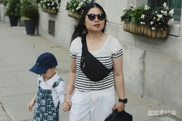 高清摄影 女人和孩子手牵着手在户外散步。