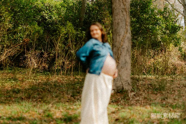 高清摄影 穿着牛仔夹克和白色连衣裙的孕妇在户外。