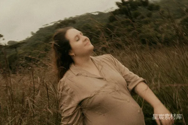 高清摄影 在一个女人怀抱着树的女人站在田野里。