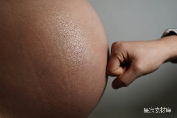 高清摄影 一只拳头轻轻地拍在孕妇的肚皮上。
