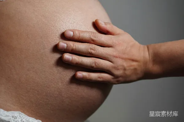 高清摄影 一只手轻轻地放在一个怀孕的肚子上。