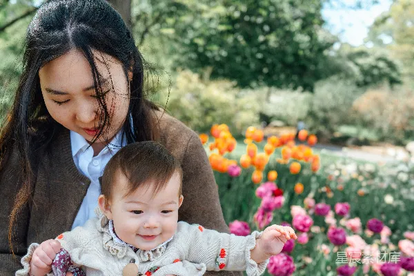 高清摄影 母亲在种着郁金香的花园里抱着一个婴儿。