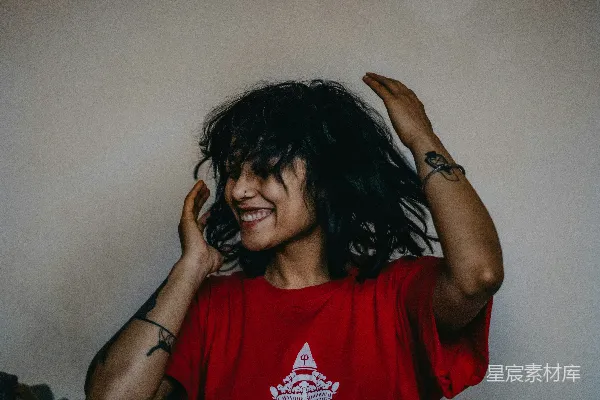 高清摄影 一个黑发的女人在微笑，并将双手放在头顶后面。