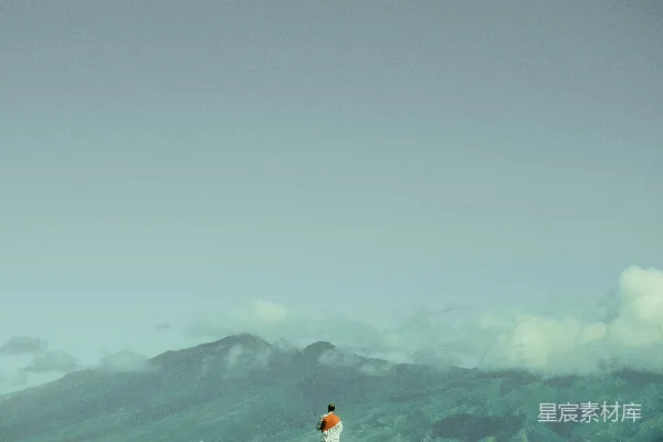 高清摄影 一个人站在白天的绿色山脉前面