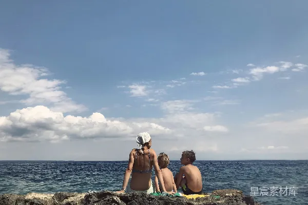 高清摄影 一群人在水边的岩石上坐着。