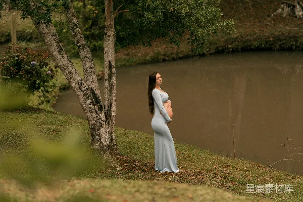 高清摄影 穿浅蓝色连衣裙的孕妇在湖边